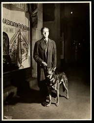 Homme aveugle et son chien guide sur le trottoir devant l